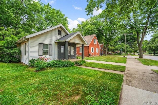 2124 Catalpa Dr, Berkley, MI 48072 - bungalow-style home featuring a front lawn, view of scattered trees, and brick siding