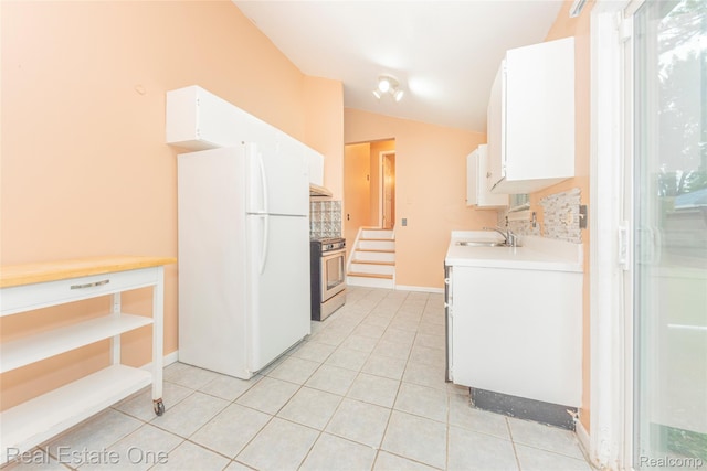 31121 Avondale St, Westland, MI 48186 - kitchen featuring freestanding refrigerator, stainless steel gas stove, light countertops, white cabinetry, and decorative backsplash