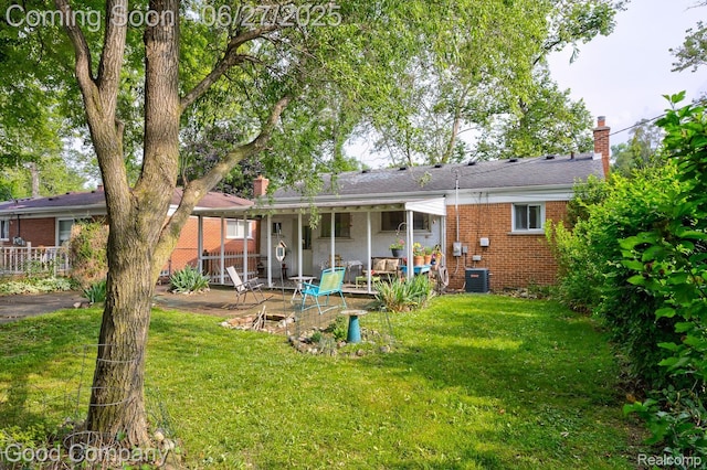 24745 Ross Dr, Redford, MI 48239 - back of property featuring brick siding, a chimney, and a lawn
