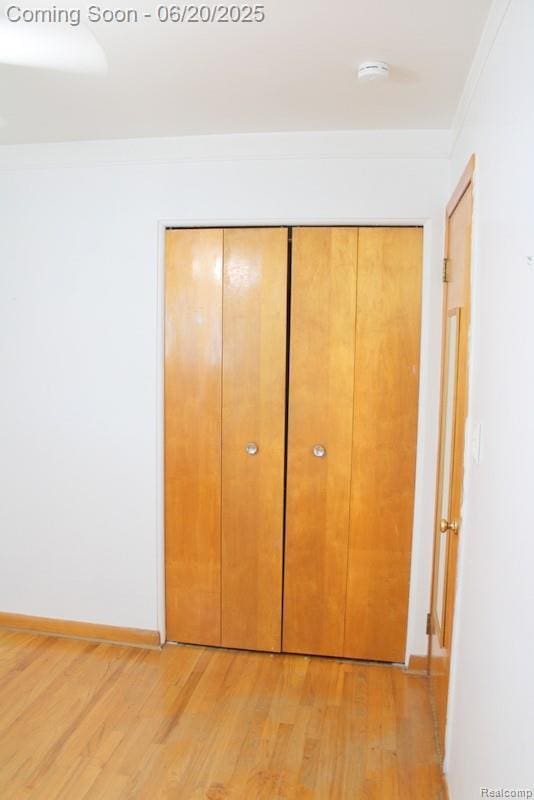 9396 Allen Rd, Allen Park, MI 48101 - unfurnished bedroom with light wood-style flooring, a closet, and crown molding