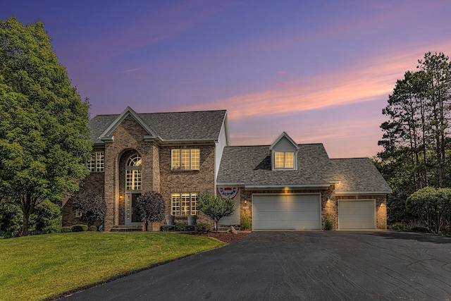 10310 E Rivershore Dr SE, Alto, MI 49302 - view of front of home featuring driveway, a front yard, a garage, brick siding, and a shingled roof