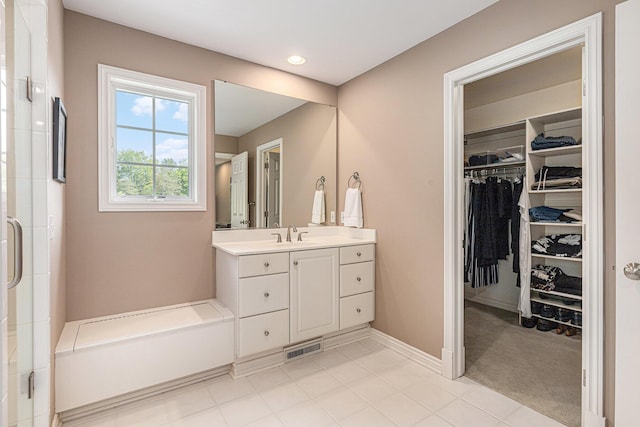 10310 E Rivershore Dr SE, Alto, MI 49302 - bathroom with vanity, a walk in closet, a shower with shower door, tile patterned floors, and recessed lighting