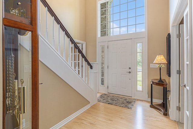 10310 E Rivershore Dr SE, Alto, MI 49302 - entryway featuring wood finished floors, a towering ceiling, and stairway