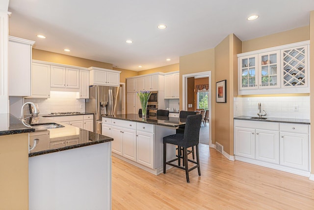 10310 E Rivershore Dr SE, Alto, MI 49302 - kitchen with appliances with stainless steel finishes, a breakfast bar, light wood-style flooring, white cabinets, and recessed lighting