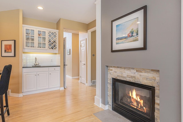 10310 E Rivershore Dr SE, Alto, MI 49302 - interior space featuring light wood finished floors, a fireplace, bar area, and recessed lighting
