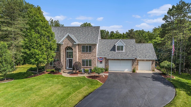 10310 E Rivershore Dr SE, Alto, MI 49302 - view of front of house with driveway, a front yard, a garage, brick siding, and roof with shingles