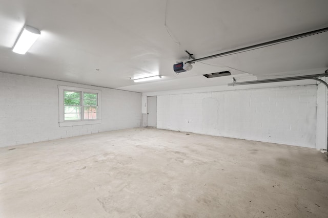 5615 Carlburt St, West Bloomfield, MI 48322 - garage featuring a garage door opener and concrete block wall