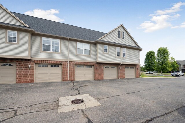3328 Primrose Ln, Ypsilanti, MI 48197 - view of home's exterior featuring an attached garage, brick siding, and driveway