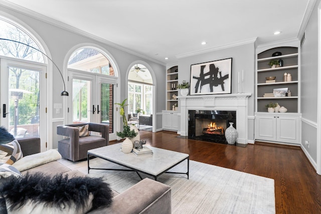 1303 Towsley Ln, Ann Arbor, MI 48105 - living room featuring a fireplace, wood finished floors, built in shelves, crown molding, and french doors