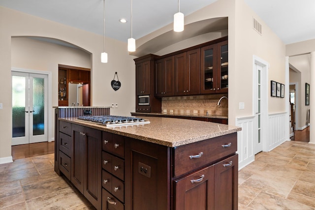 1303 Towsley Ln, Ann Arbor, MI 48105 - kitchen with stainless steel appliances, dark brown cabinetry, stone tile flooring, decorative backsplash, and recessed lighting