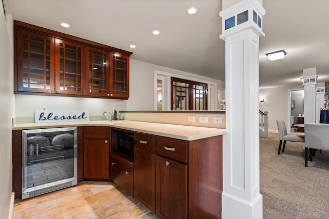 1303 Towsley Ln, Ann Arbor, MI 48105 - kitchen featuring beverage cooler, built in microwave, glass insert cabinets, decorative columns, and a peninsula
