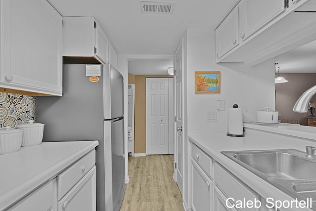 3360 Pine Meadow Dr SE Unit 202, Kentwood, MI 49512 - kitchen with white cabinets, light countertops, light wood-style floors, and freestanding refrigerator