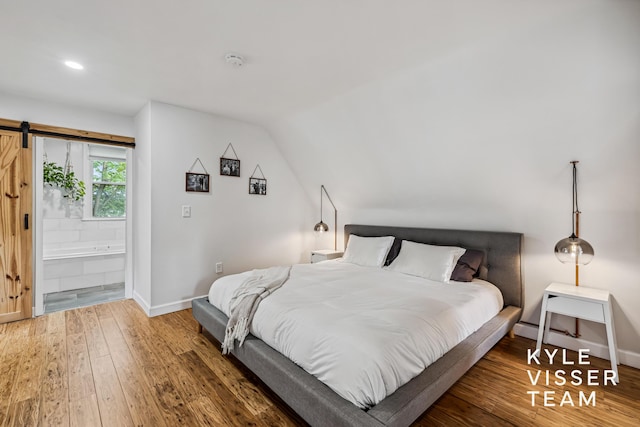 1624 Boston St SE, Grand Rapids, MI 49506 - bedroom featuring wood finished floors, a barn door, recessed lighting, and lofted ceiling