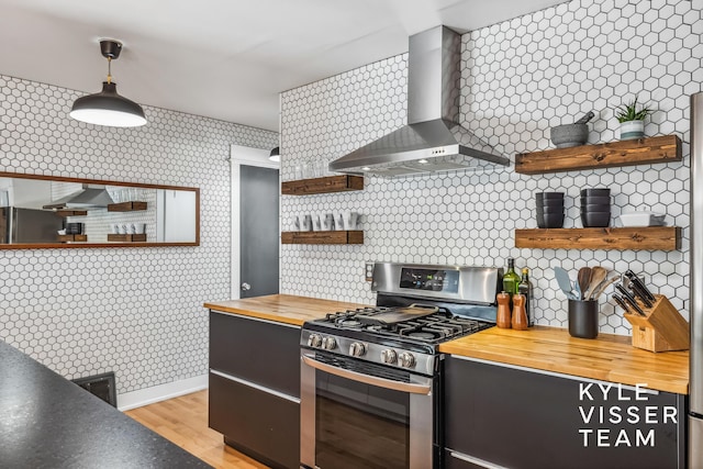 1624 Boston St SE, Grand Rapids, MI 49506 - kitchen featuring appliances with stainless steel finishes, open shelves, butcher block counters, wall chimney exhaust hood, and tasteful backsplash