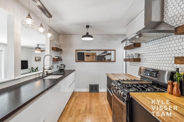 1624 Boston St SE, Grand Rapids, MI 49506 - kitchen featuring gas stove, open shelves, wall chimney exhaust hood, butcher block counters, and ceiling fan