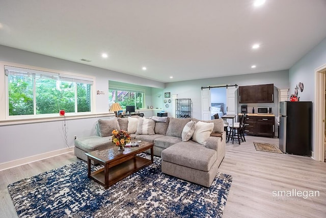 3440 Monterey Hills Dr NE, Grand Rapids, MI 49525 - living area featuring a barn door, light wood-style floors, and recessed lighting