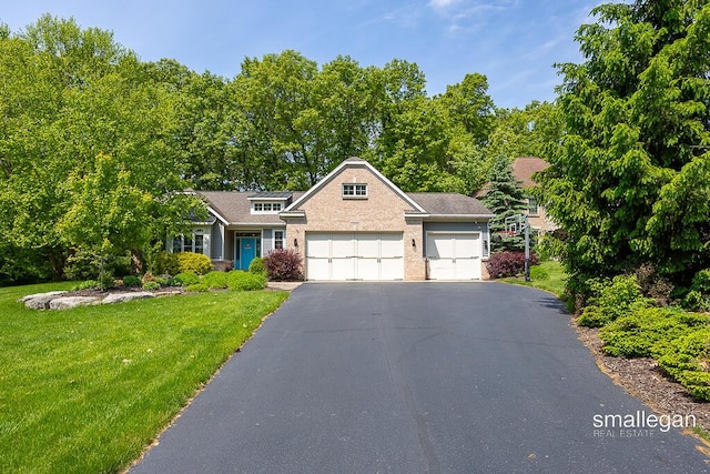 3440 Monterey Hills Dr NE, Grand Rapids, MI 49525 - traditional-style home featuring a garage, a front lawn, asphalt driveway, and brick siding