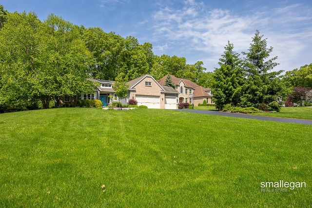 3440 Monterey Hills Dr NE, Grand Rapids, MI 49525 - view of front of house with an attached garage, a front lawn, and asphalt driveway