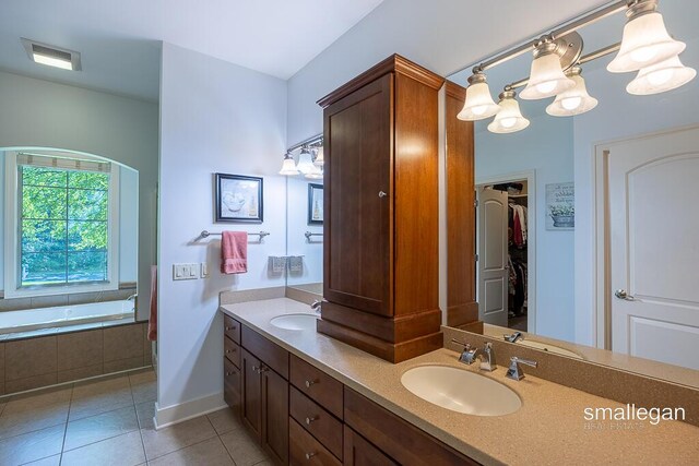 3440 Monterey Hills Dr NE, Grand Rapids, MI 49525 - full bathroom featuring tile patterned floors, double vanity, tiled tub, a chandelier, and a walk in closet