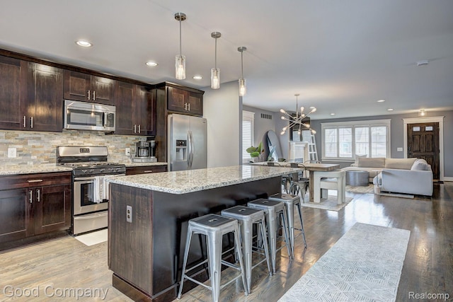 995 Cambridge Rd, Berkley, MI 48072 - kitchen featuring appliances with stainless steel finishes, a breakfast bar area, open floor plan, a center island, and a chandelier