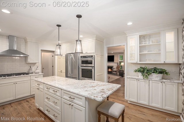 1337 Knollcrest Cir, Bloomfield Hills, MI 48304 - kitchen with wall chimney range hood, stainless steel appliances, white cabinets, decorative backsplash, and glass insert cabinets