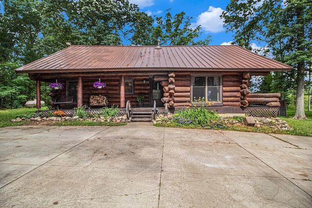 12170 Riethmiller Rd, Grass Lake, MI 49240 - log home featuring covered porch, log siding, and a metal roof
