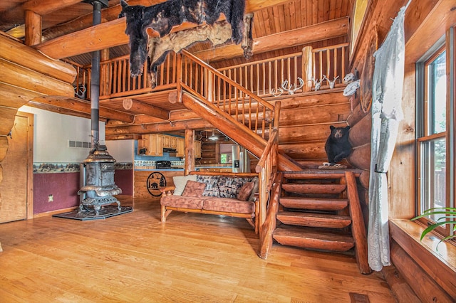 12170 Riethmiller Rd, Grass Lake, MI 49240 - stairs with log walls, wood finished floors, and a wood stove