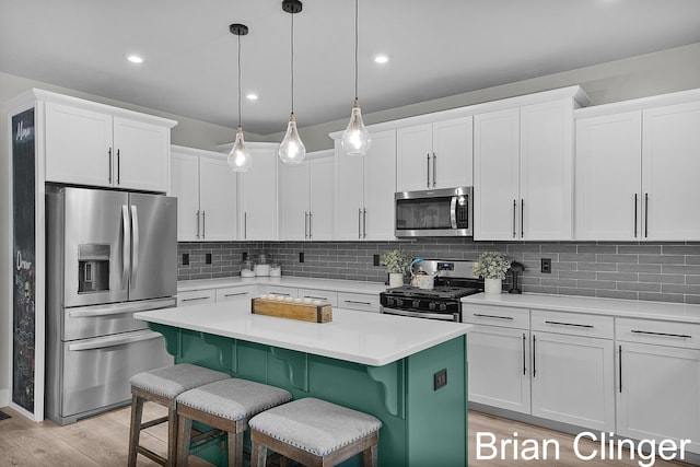 3293 Creek Ridge Dr, Hudsonville, MI 49426 - kitchen featuring stainless steel appliances, a kitchen breakfast bar, white cabinets, tasteful backsplash, and recessed lighting