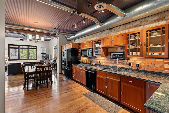 333 State St Unit 5, Saint Joseph, MI 49085 - kitchen featuring black appliances, brown cabinets, light wood-type flooring, glass insert cabinets, and pendant lighting
