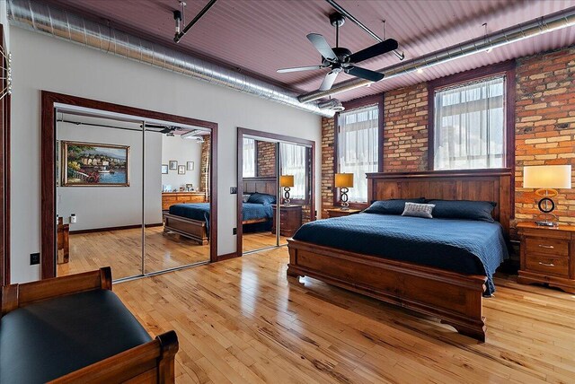 333 State St Unit 5, Saint Joseph, MI 49085 - bedroom with brick wall, multiple closets, light wood-style flooring, and ceiling fan