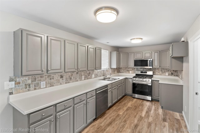 7220 Dodge Ave, Warren, MI 48091 - kitchen with gray cabinetry, stainless steel appliances, tasteful backsplash, and light wood-style floors