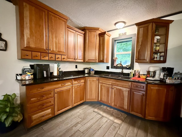 13820 Morenci Rd, Morenci, MI 49256 - kitchen with wood finished floors, a textured ceiling, brown cabinets, and glass insert cabinets