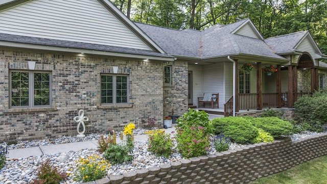 1255 White Pine Dr SW, Grand Rapids, MI 49534 - view of front facade with a porch, a shingled roof, and brick siding