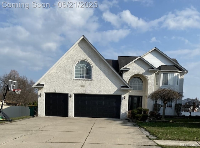 27363 Lilly Ct, Trenton, MI 48183 - french country style house with concrete driveway, brick siding, and an attached garage