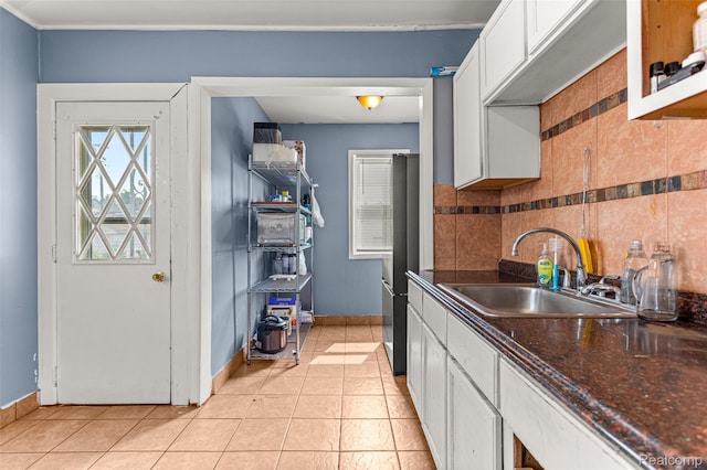 6842 Jonathon St, Dearborn, MI 48126 - kitchen featuring white cabinets, freestanding refrigerator, light tile patterned floors, and tasteful backsplash