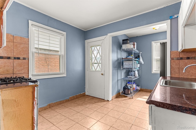 6842 Jonathon St, Dearborn, MI 48126 - kitchen with light tile patterned flooring, stainless steel range with gas stovetop, dark countertops, white cabinetry, and tasteful backsplash