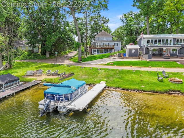 5443 Ridgemont St, Howell, MI 48843 - dock area featuring boat lift, a deck with water view, a yard, and a fire pit