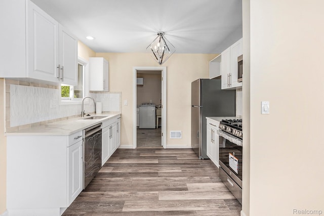 27336 Alger Blvd, Bloomfield Hills, MI 48071 - kitchen with stainless steel appliances, washer / dryer, white cabinetry, tasteful backsplash, and light wood-type flooring