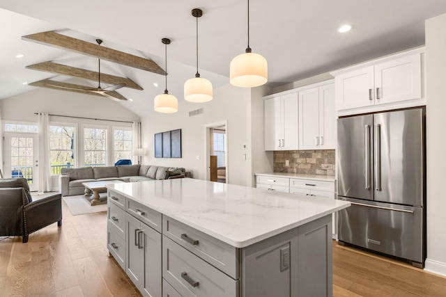 3078 N Spurway Dr, Ann Arbor, MI 48105 - kitchen featuring high end refrigerator, open floor plan, light wood-style flooring, a center island, and decorative backsplash