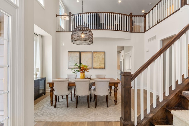 3078 N Spurway Dr, Ann Arbor, MI 48105 - dining room featuring stairway, wood finished floors, a high ceiling, and healthy amount of natural light