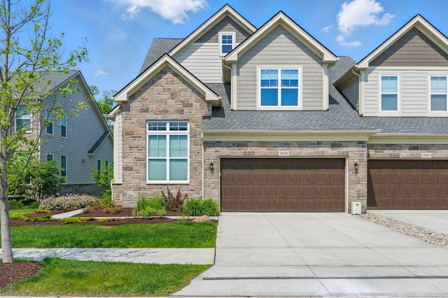 3078 N Spurway Dr, Ann Arbor, MI 48105 - craftsman inspired home with stone siding, an attached garage, and roof with shingles
