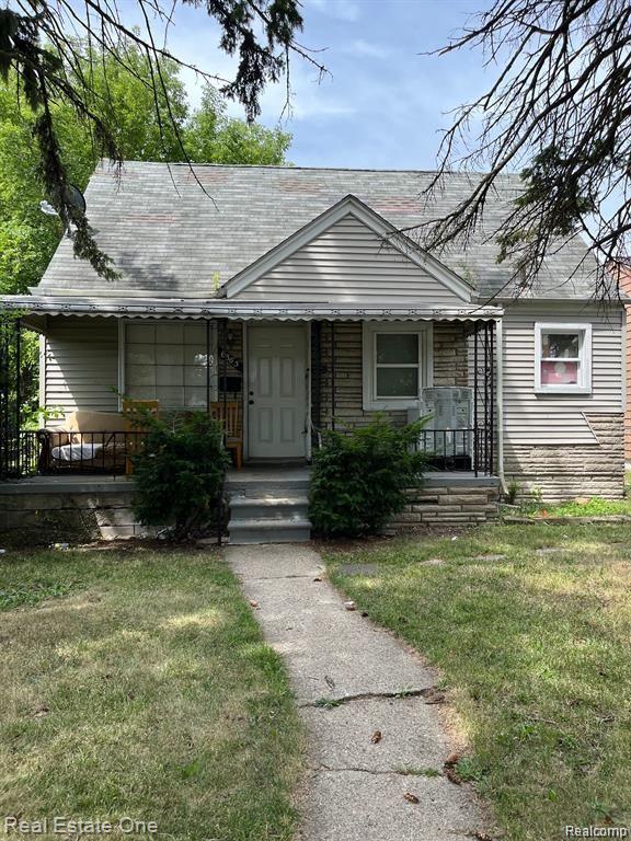 6365 Longacre St, Detroit, MI 48228 - view of front facade with a porch, a front yard, and roof with shingles