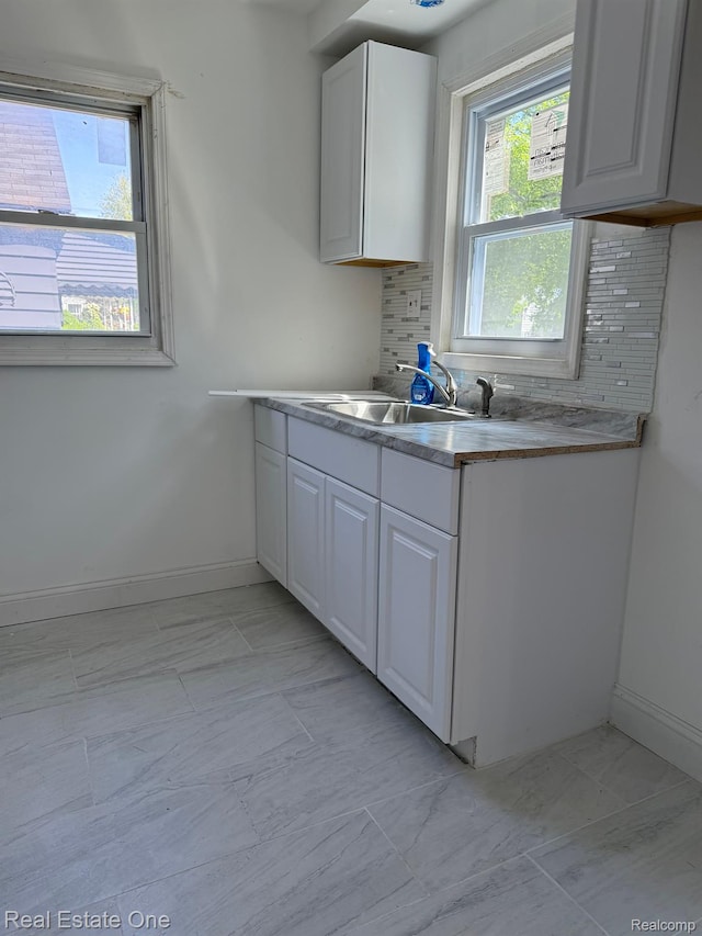 6365 Longacre St, Detroit, MI 48228 - kitchen featuring tasteful backsplash, white cabinets, and light marble finish floors