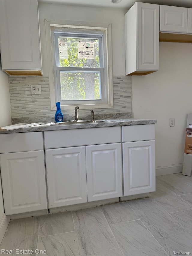 6365 Longacre St, Detroit, MI 48228 - kitchen with white cabinets, decorative backsplash, and light marble finish floors