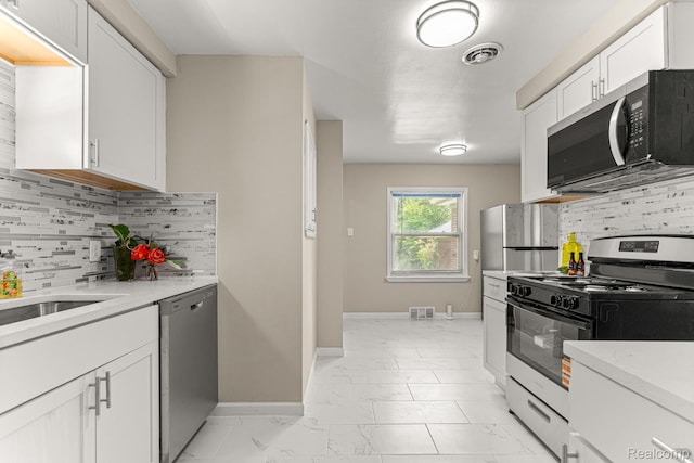 23621 Joy Rd, Redford, MI 48127 - kitchen with appliances with stainless steel finishes, light marble finish floors, light countertops, white cabinetry, and decorative backsplash