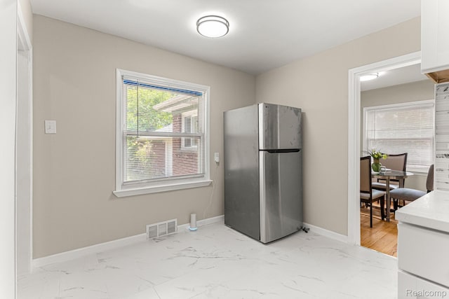 23621 Joy Rd, Redford, MI 48127 - kitchen featuring freestanding refrigerator, light marble finish floors, white cabinets, and light countertops