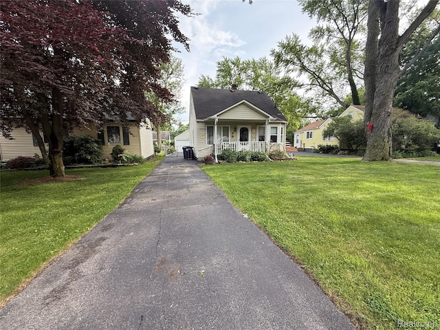 35717 Columbia Ave, Westland, MI 48186 - bungalow-style house featuring covered porch, a front yard, an outdoor structure, and a detached garage