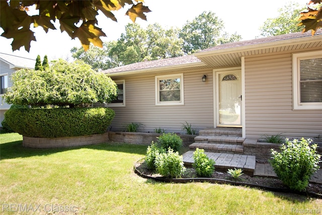 5280 Weston Ct, Commerce Twp, MI 48382 - view of exterior entry featuring a yard and roof with shingles