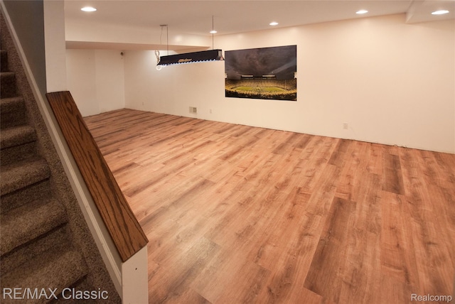 5280 Weston Ct, Commerce Twp, MI 48382 - finished basement with wood finished floors, stairway, and recessed lighting