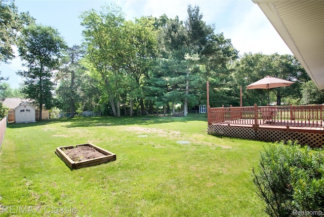 5280 Weston Ct, Commerce Twp, MI 48382 - fenced yard with a storage unit, a deck, a vegetable garden, and view of wooded area